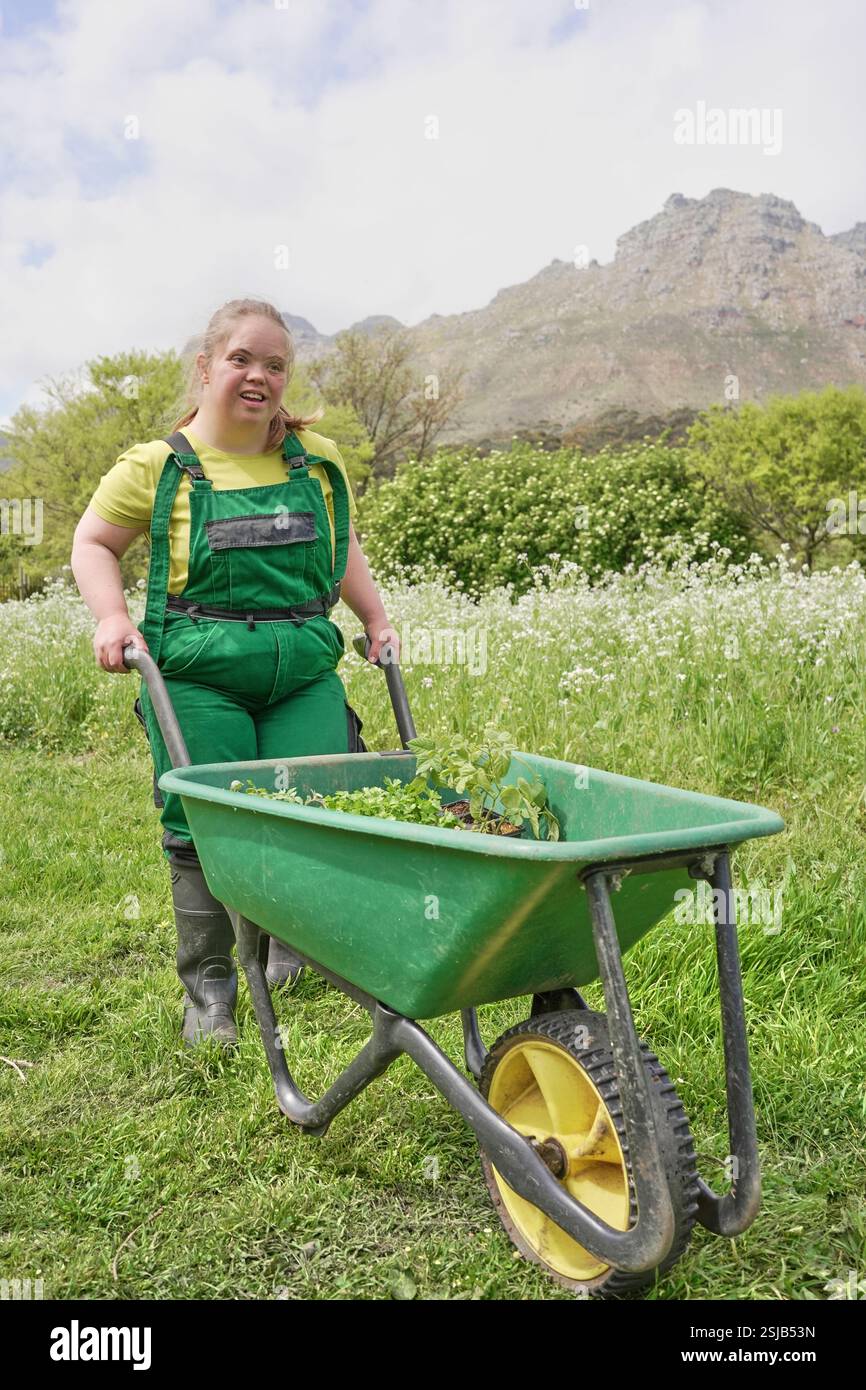Female farmer pushing wheelbarrow in garden Stock Photo - Alamy