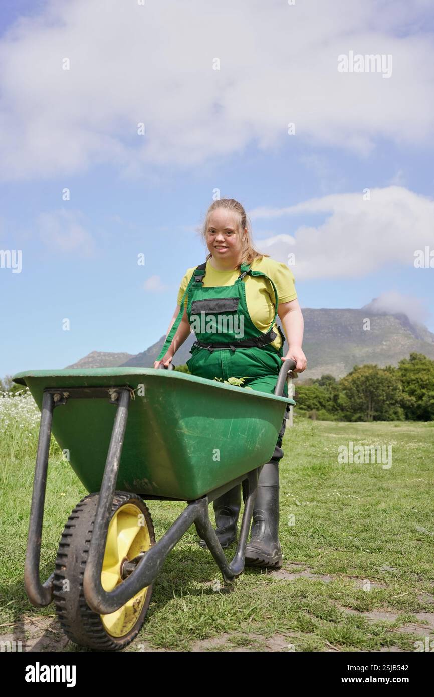 Female farmer pushing wheelbarrow in garden Stock Photo - Alamy