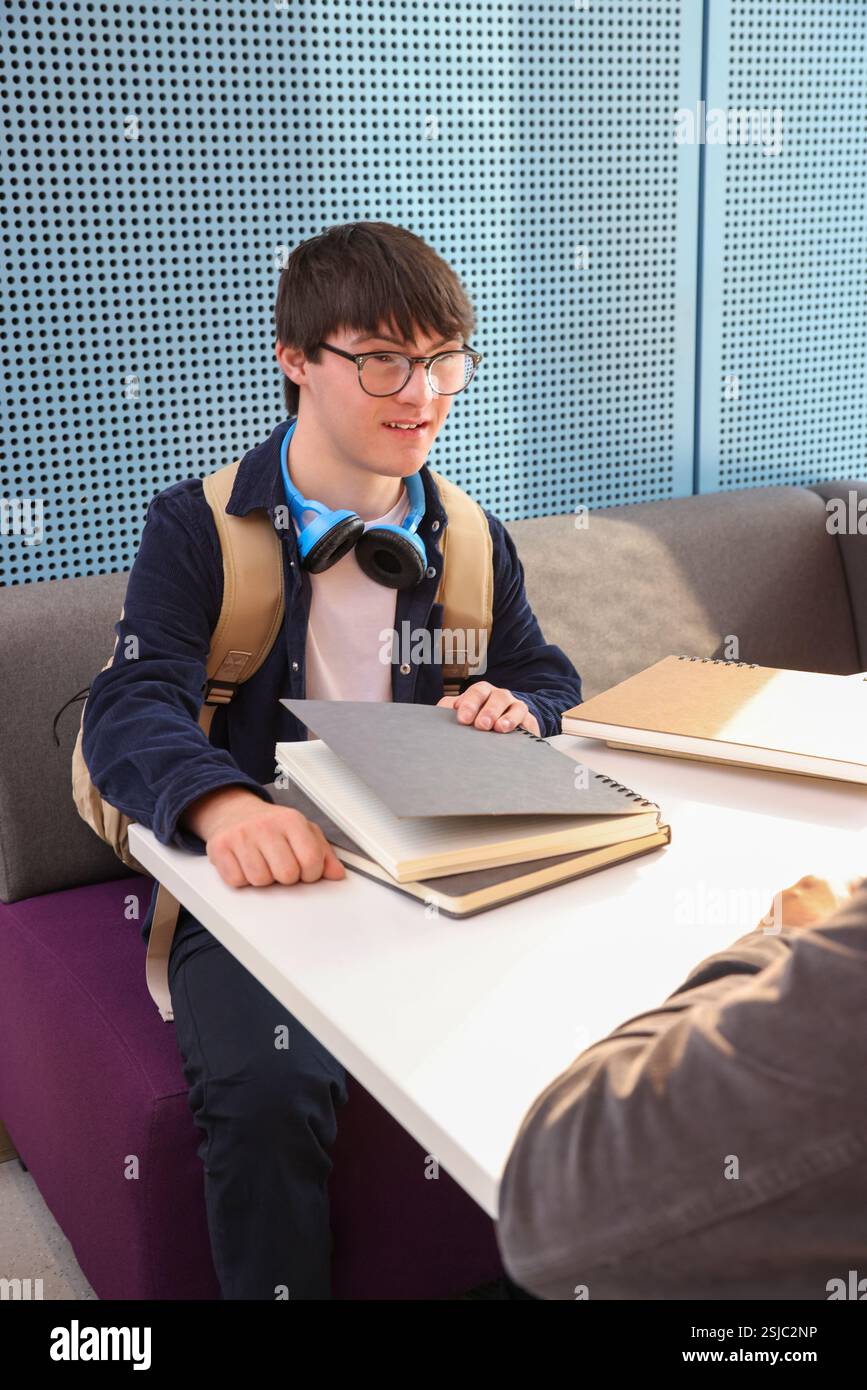 Man with Down Syndrome sitting at table Stock Photo