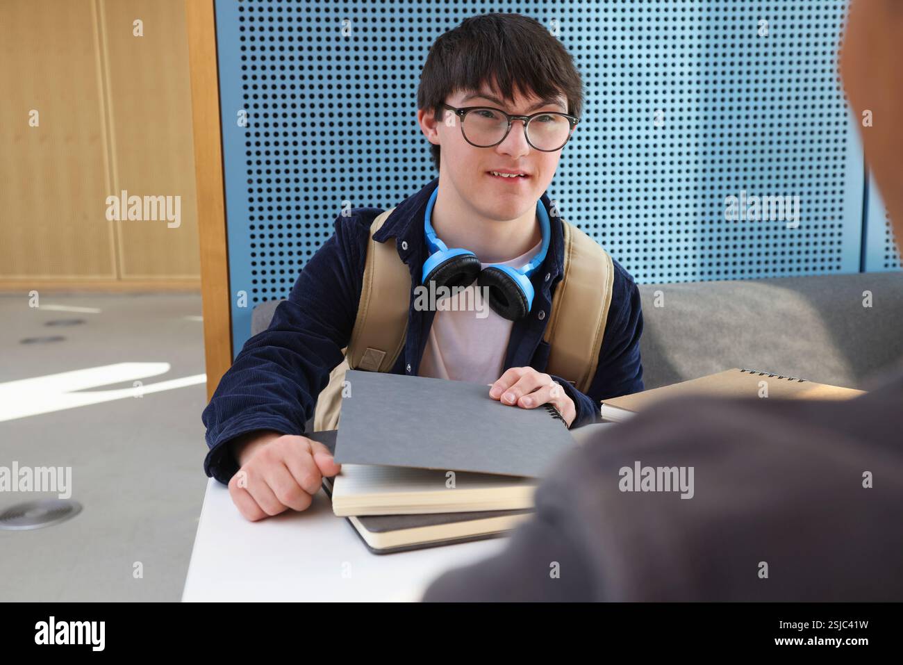 Man with Down Syndrome sitting at table Stock Photo