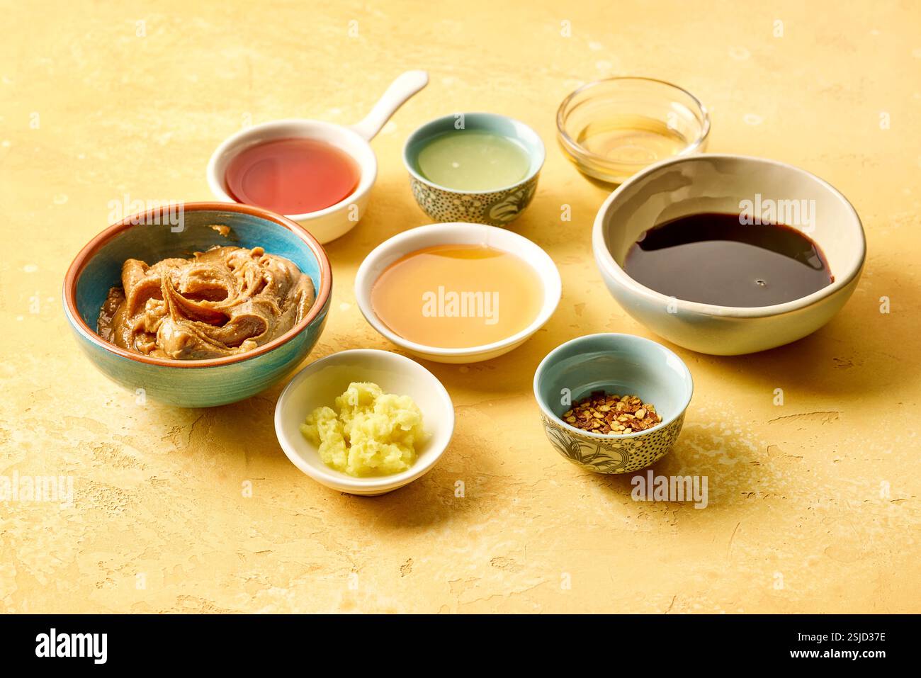 various salad dressing ingredients on yellow table background Stock Photo