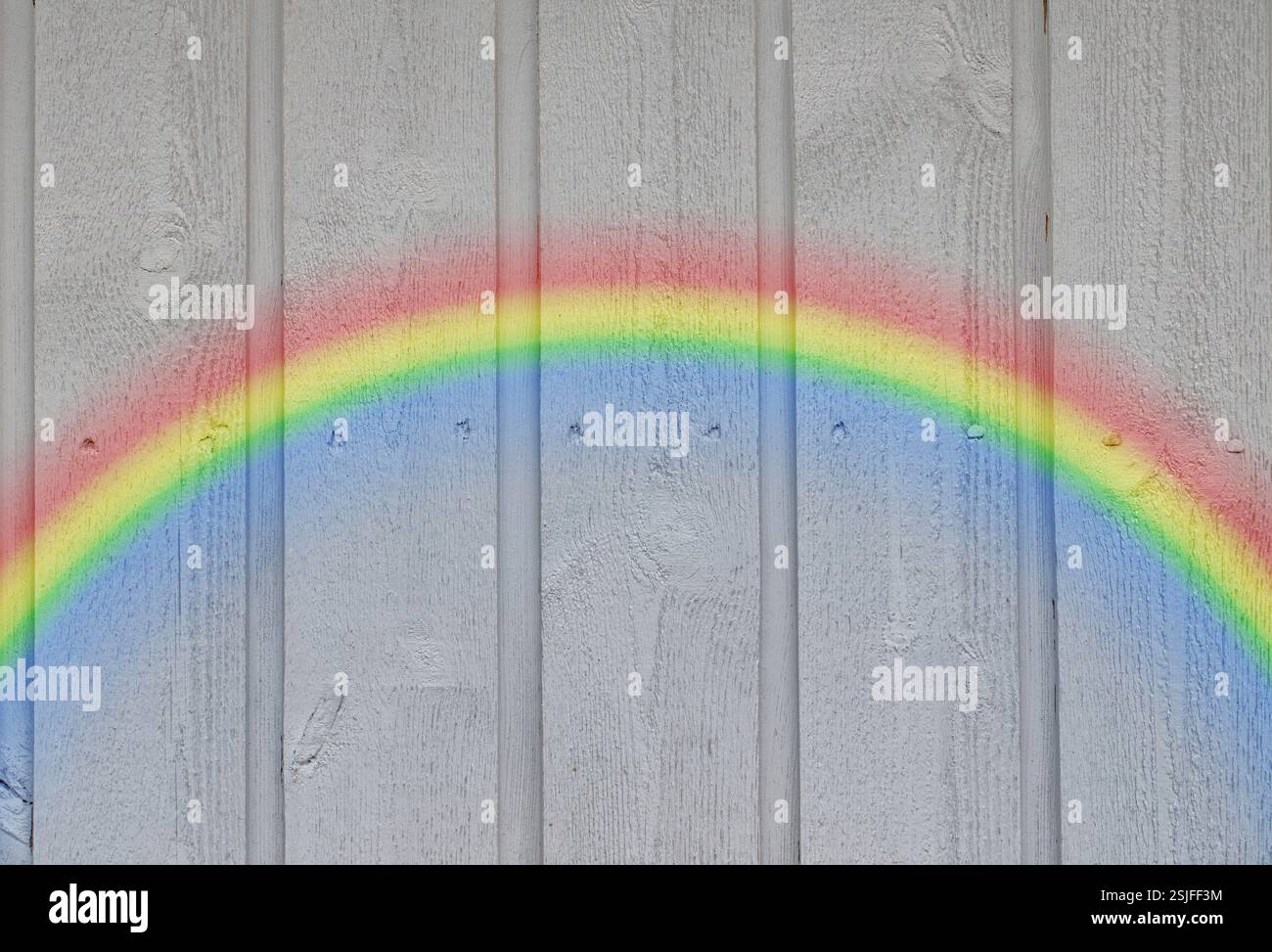 Wooden wall background with a rainbow Stock Photo