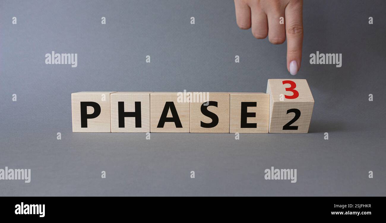From Phase 2 to 3 symbol. Businessman Hand points at wooden cubes with ...