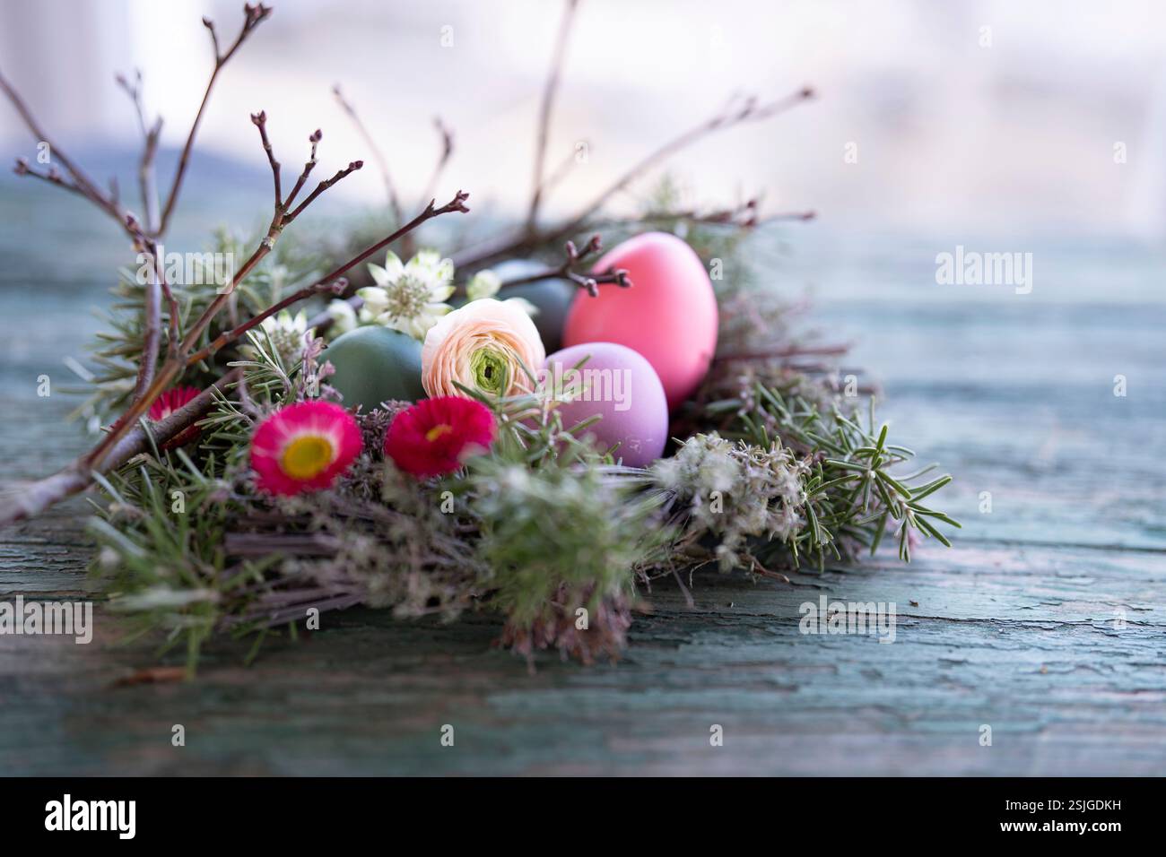 Easter eggs decorated with colorful spring flowers on old rustic wood surface. Stock Photo