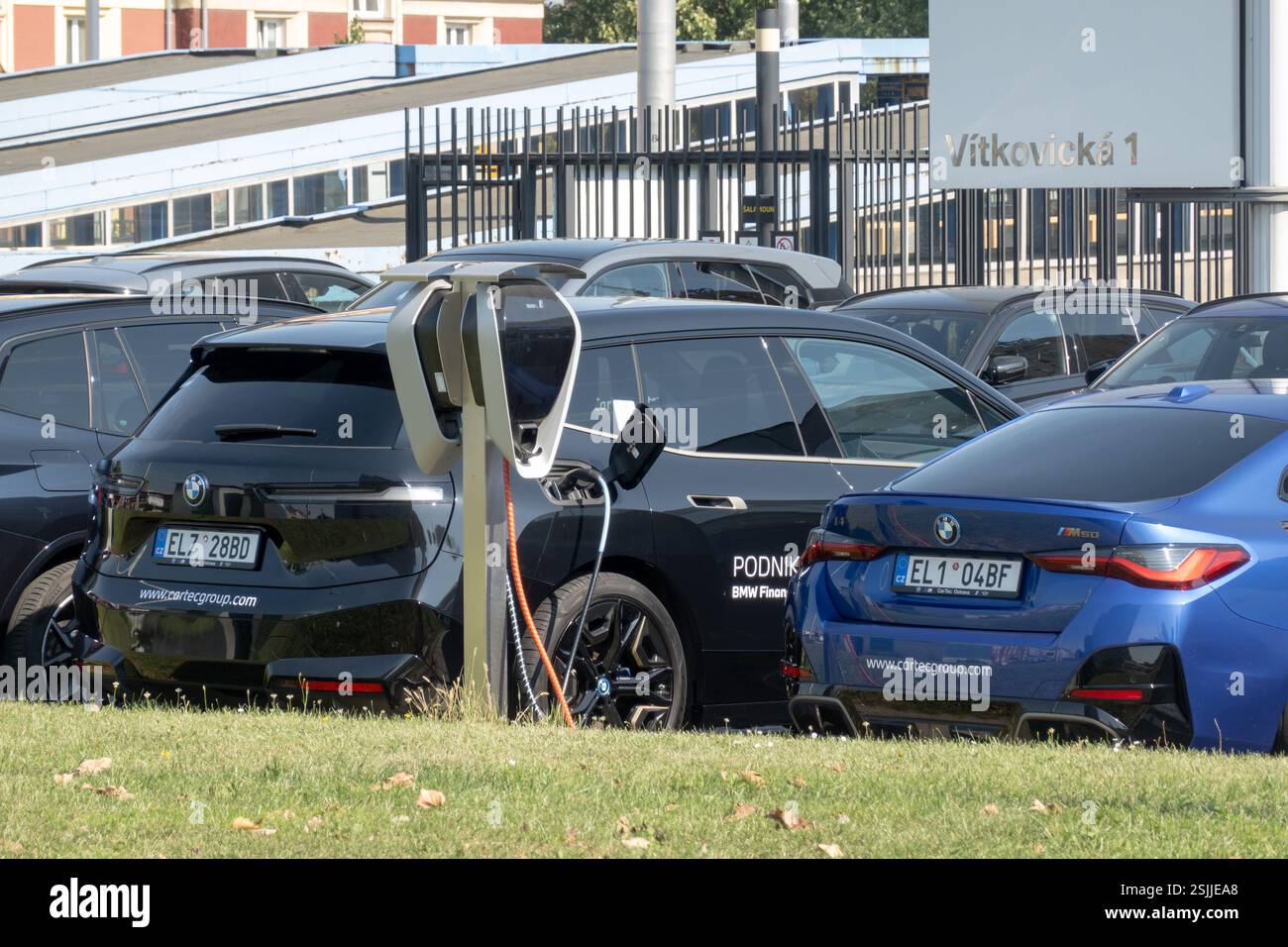 OSTRAVA, CZECHIA - SEPTEMBER 13, 2023: Charging BMW iX electric car at dealership, i4 M50 vehicle next to it Stock Photo