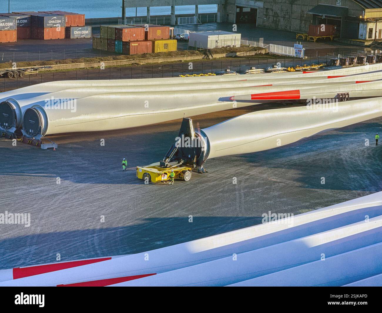 Le Havre, France, Europe - 16 January 2025: Workers using specialist remote controlled transporting equipment to move a large wind turbine blade - Smartphone Captured Stock Image