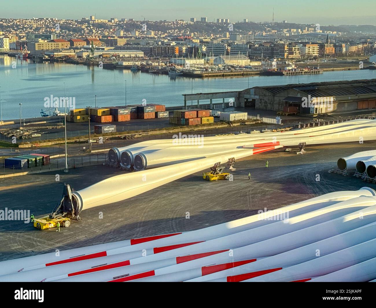 Le Havre, France, Europe - 16 January 2025: Workers using specialist remote controlled transporting equipment to move a large wind turbine blade - Smartphone Captured Stock Image