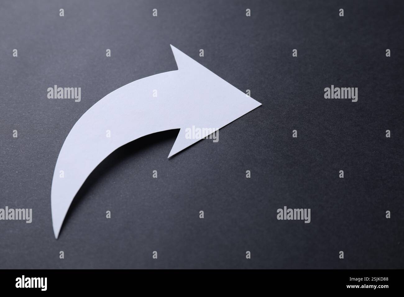 One white paper arrow on black background, closeup Stock Photo - Alamy