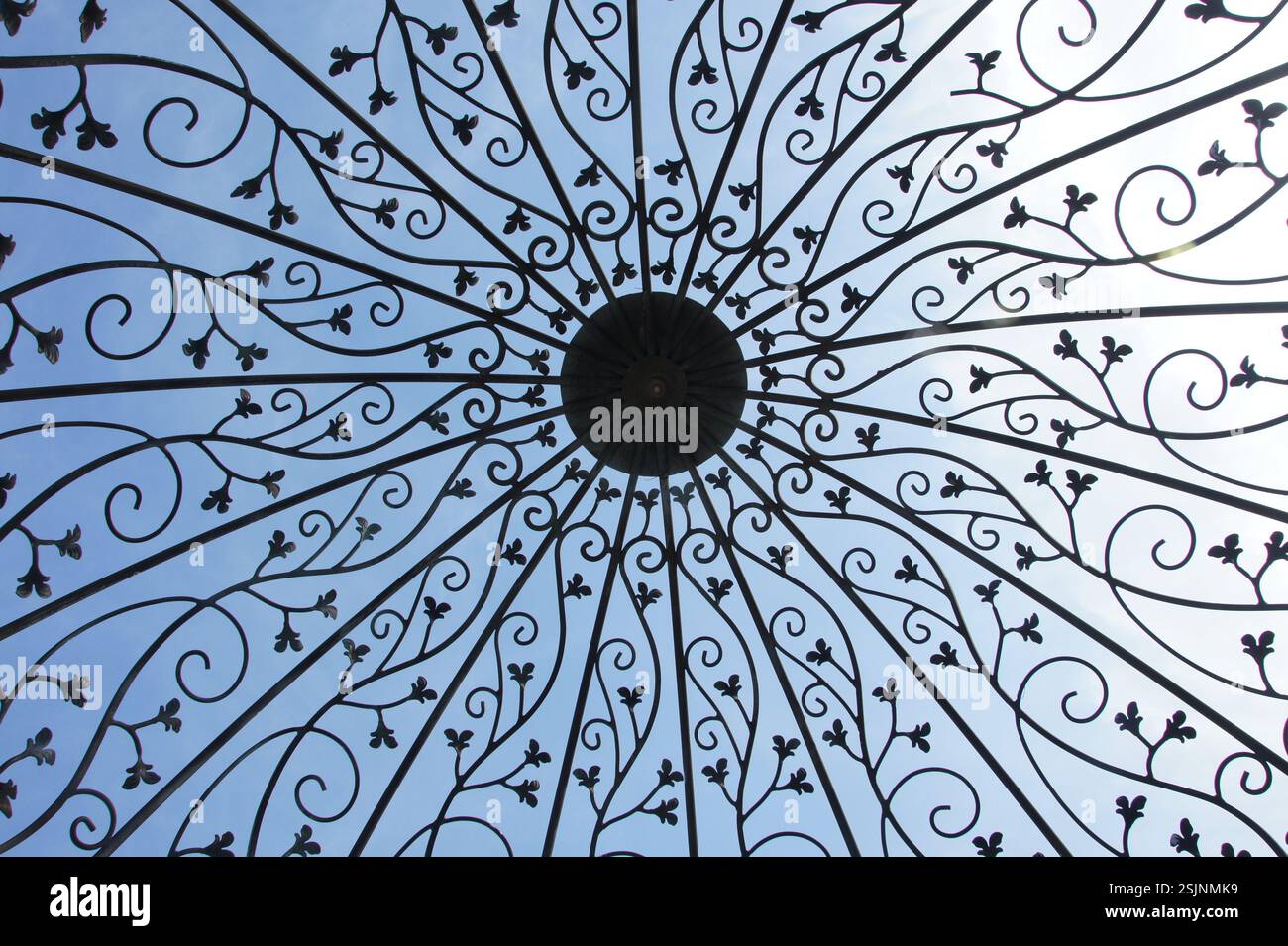 Wrought iron gazebo ceiling. Intricate floral patterns radiate outwards. Symbol of craftsmanship and beauty. Also evokes a sense of protection and she Stock Photo