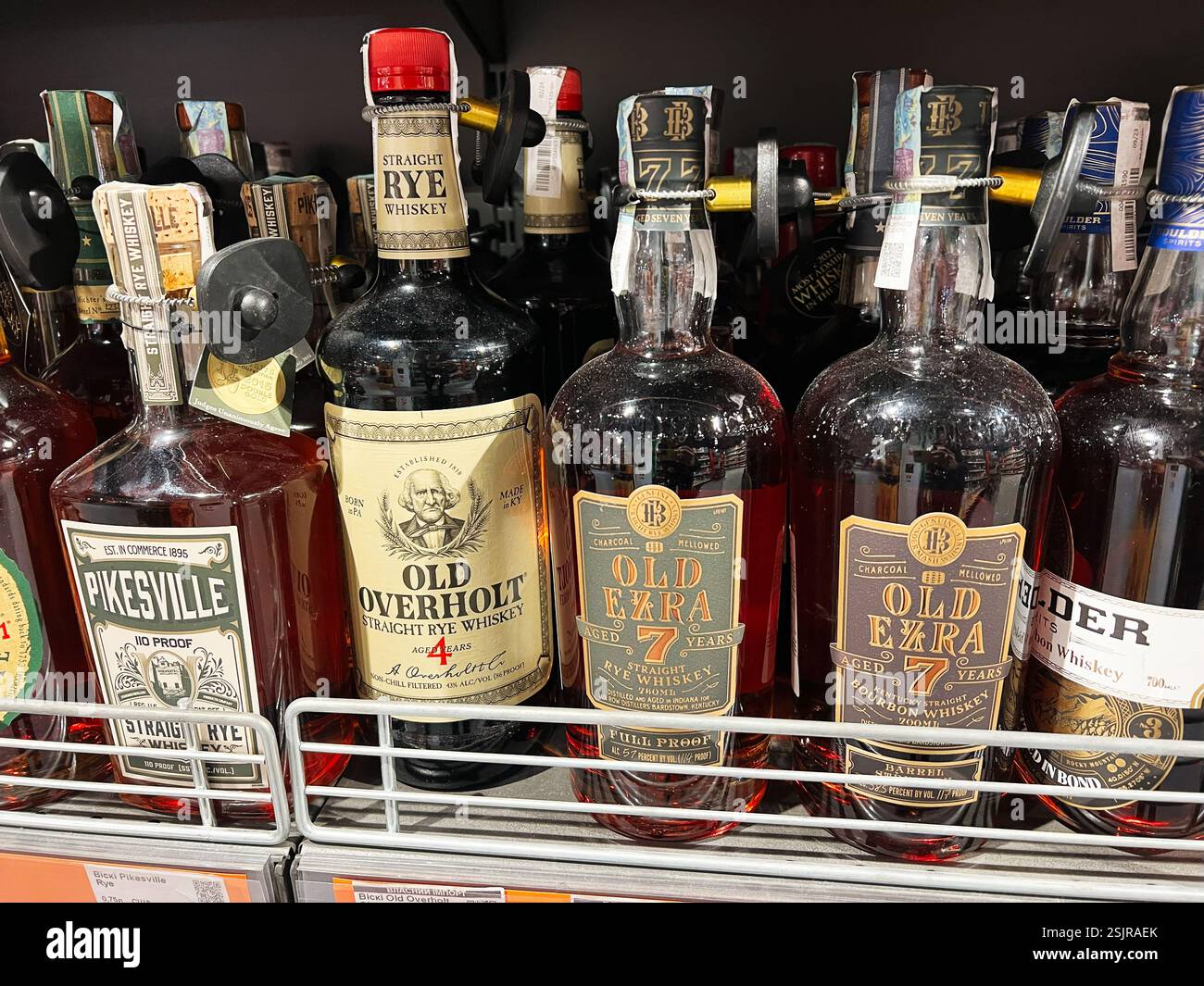 Kyiv, Ukraine - February 11, 2025: Different brands of whiskies and bourbons arranged neatly on metal shelves Stock Photo