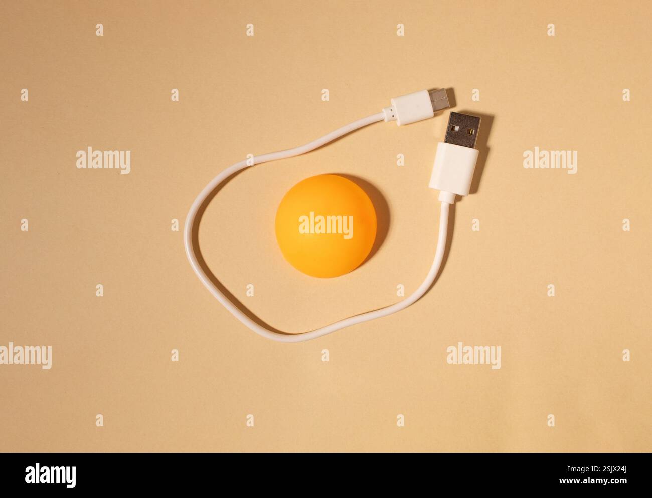 Egg made of ping pong ball and white cable on beige background. Flat lay. Christmas concept. Stock Photo