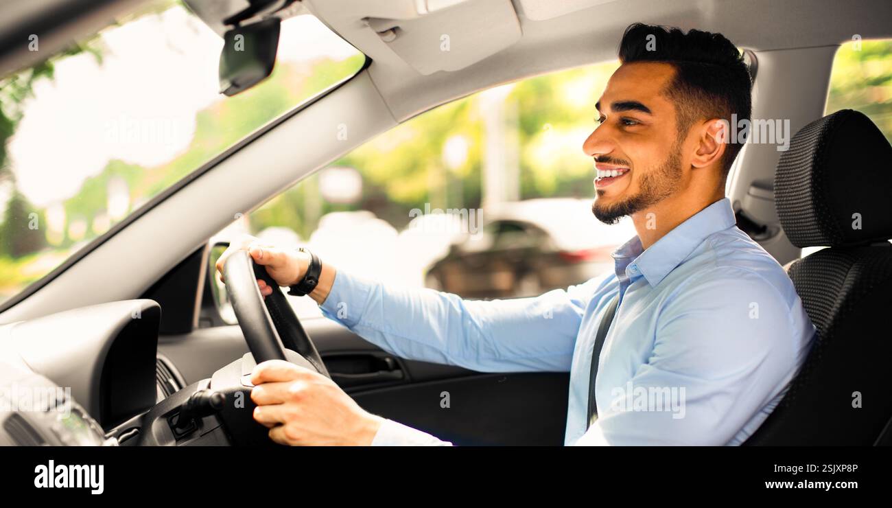 Joyful arabic guy driving nice auto, side view Stock Photo