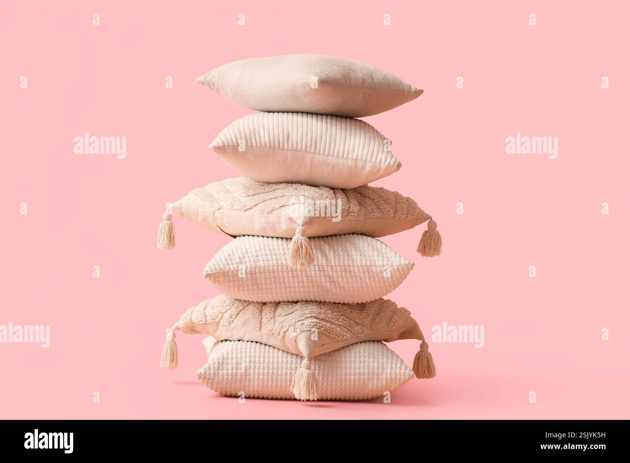 Stack of decorative pillows on pink background Stock Photo