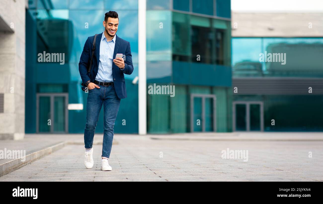 Confident arabic guy programmer with backpack walking by street Stock Photo