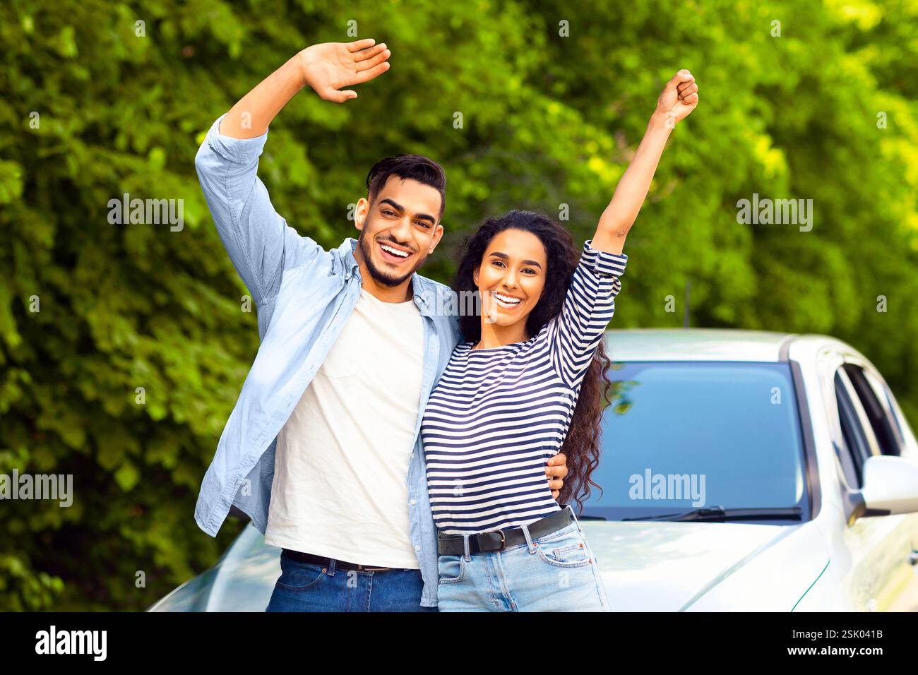 Emotional multiracial couple standing by nice auto Stock Photo