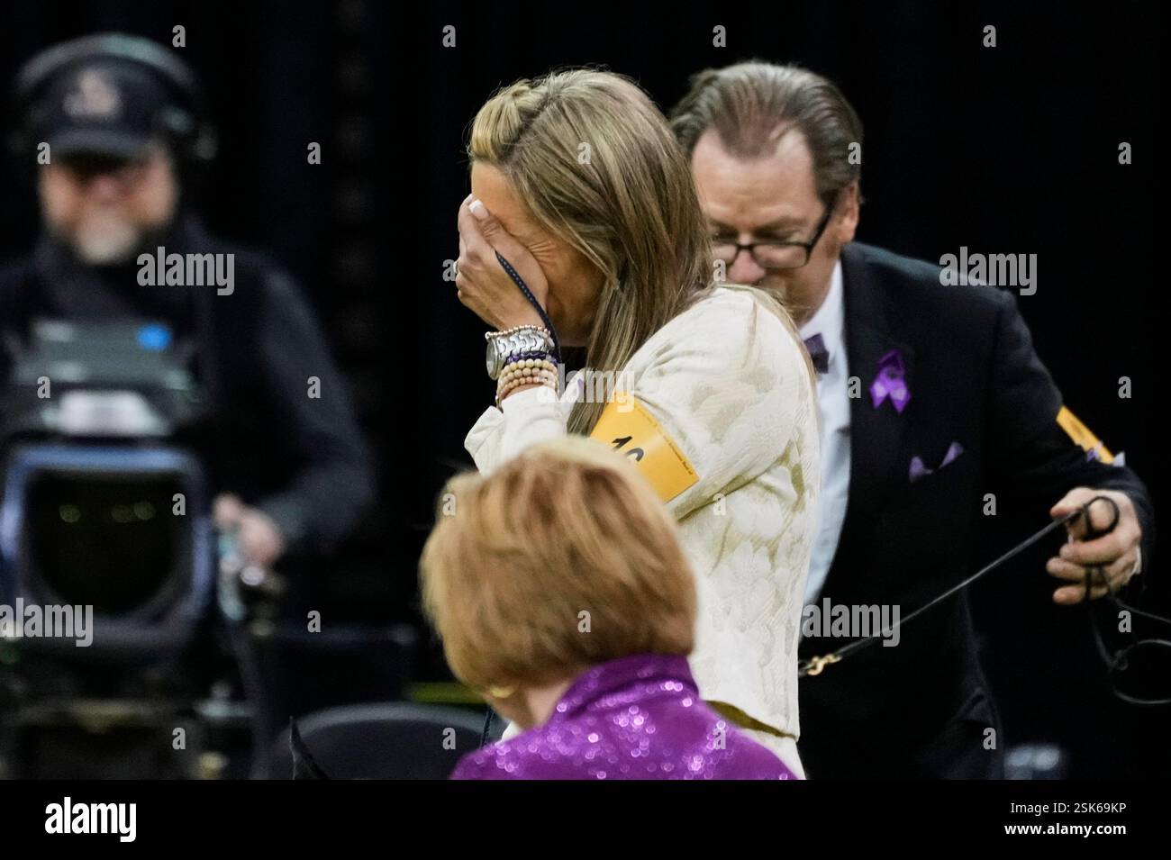 Katie Bernardin, center, reacts after winning best in show with Monty, a Giant Schnauzer, during