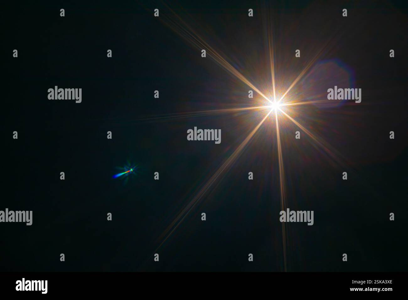 Bright sunlight shine creates lens flare light leak effects in dark background. Stock Photo