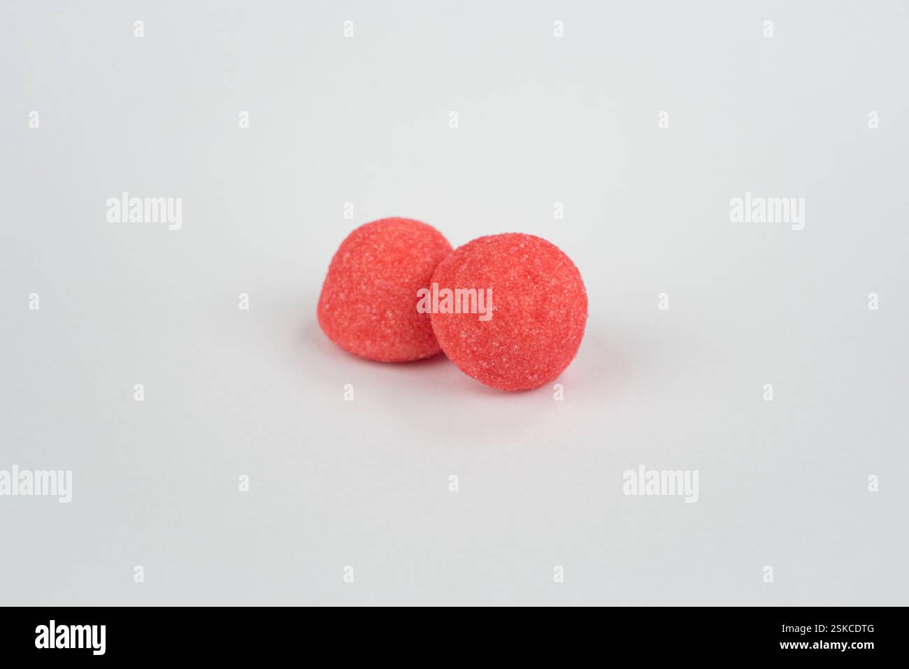 Red strawberry candies on a light grey background Stock Photo