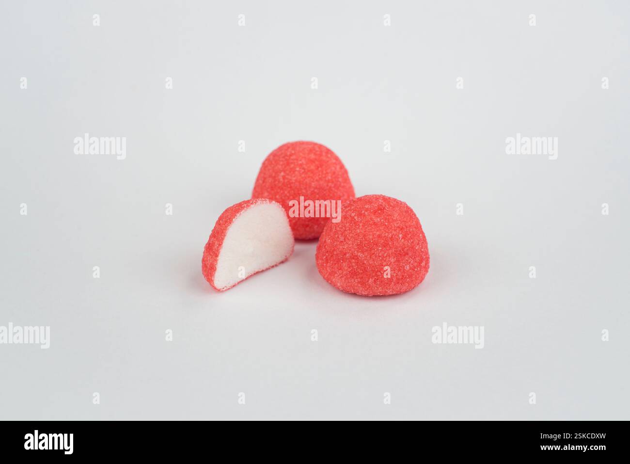 Red strawberry candies on a light grey background Stock Photo