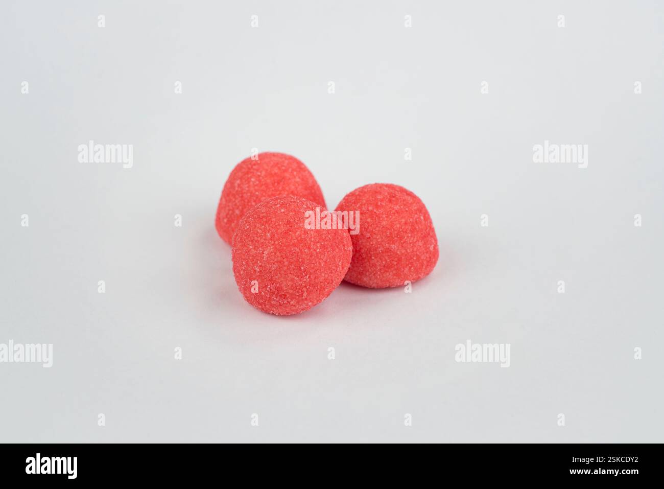 Red strawberry candies on a light grey background Stock Photo