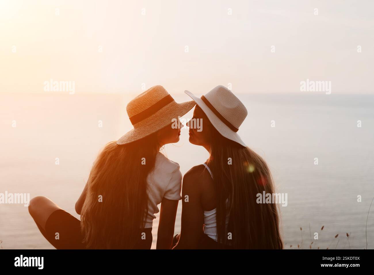 Two Women in Straw Hats Facing Each Other by the Sea Stock Photo - Alamy