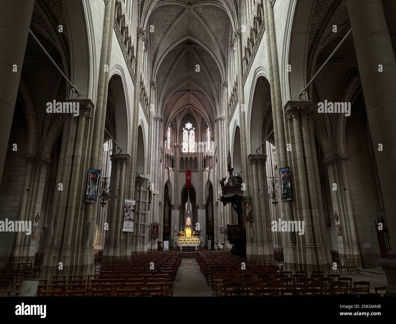 Grand Cathedral Interior showing stone vaulted ceiling and religious decoration, Stained glass windows. High walls and grand decoration. Nantes France - Smartphone Captured Stock Image