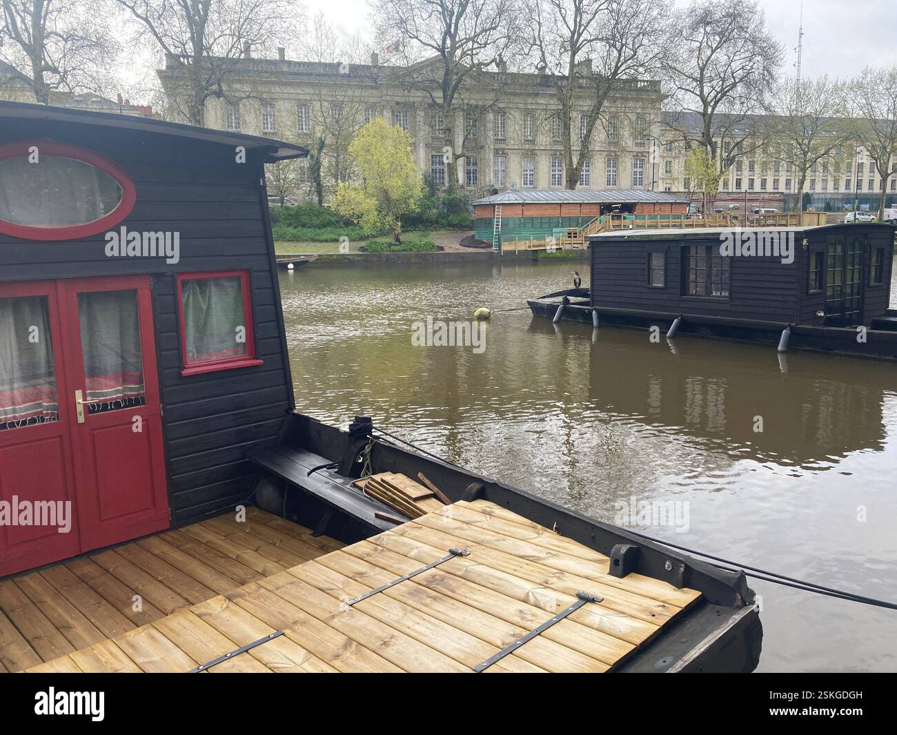 A wooden house boat on the canal in the city centre of Nantes in France. Living on the water. Old wood boat - Smartphone Captured Stock Image
