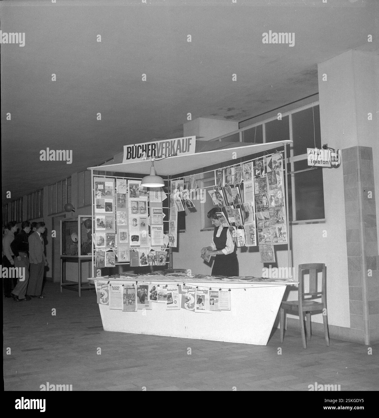 Kiosk 'Bücherverkauf' soll Jugendliche dazu animieren, gute Literatur (SJW-Hefte, Jugendzeitschriften etc.) zu lesen und nicht Schundliteratur#Kiosk 'Bücherverkauf' wants to encourage young people to read good magazines instead not trashy literature--- Jugendkiosk des Freizeitdienstes Pro Juventute, 1955#Youth Kiosk run by leasure department of Pro Juventute, 1955- RDB BY DUKAS Stock Photo