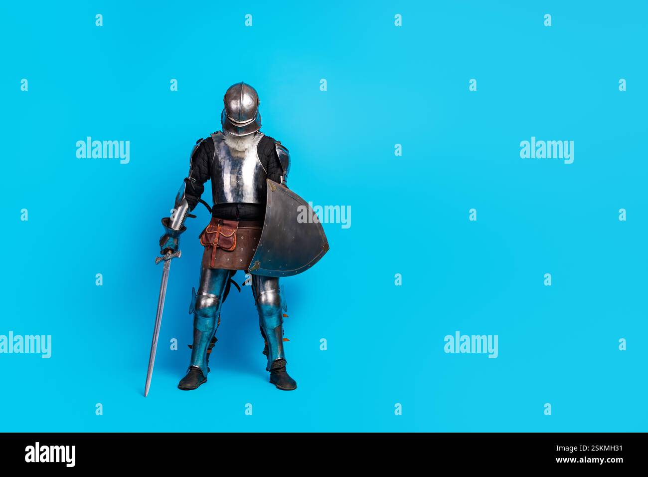 Medieval knight in full armor standing with sword and shield on vibrant ...
