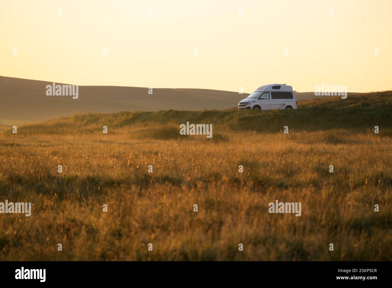 White campervan wild camping in rural countryside in golden hour light. Yorkshire Dales, UK. Stock Photo