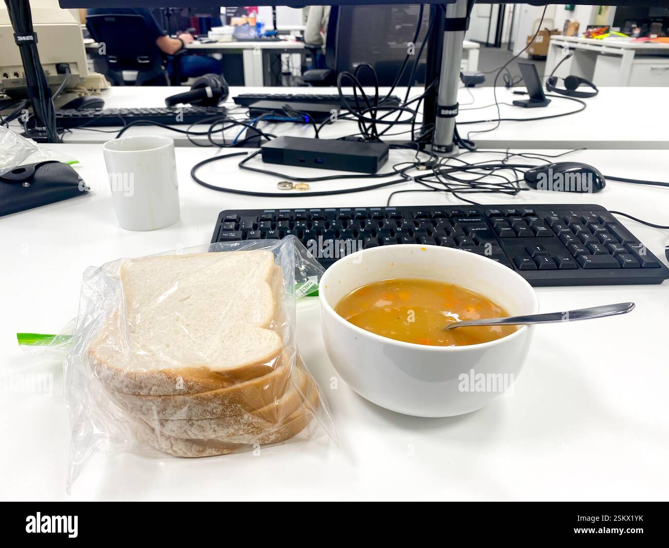 A bowl of soup, a working lunch sat at a desk in an office. - Smartphone Captured Stock Image
