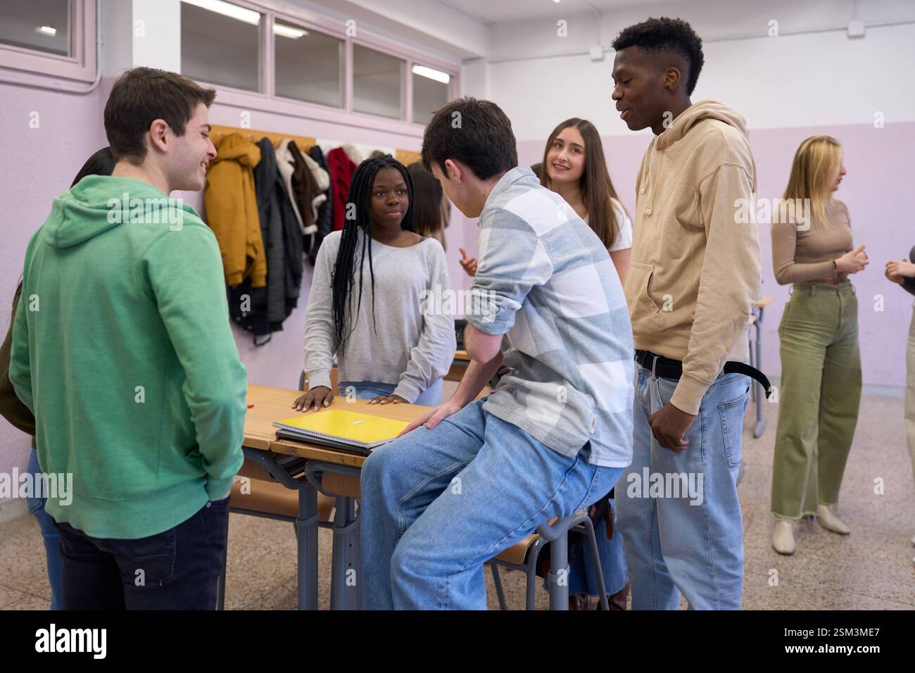 High school students chatting together in classroom Stock Photo