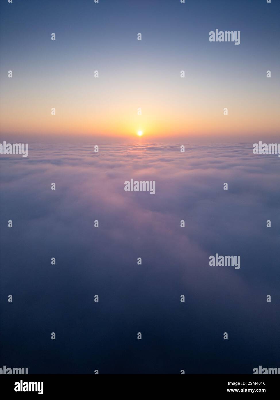 Sunrise above a vast sea of clouds. The golden light gently illuminates ...