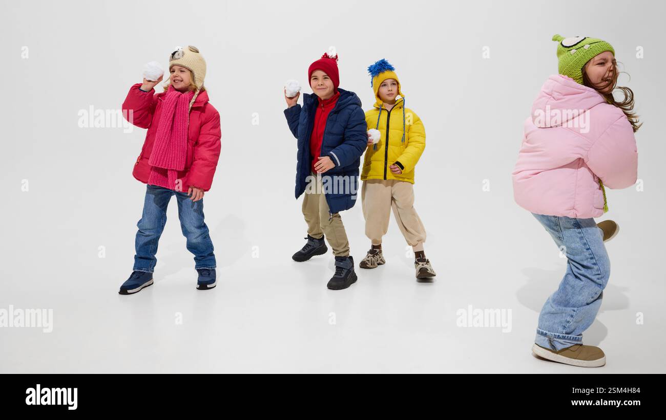 Group of children, wearing colorful winter jackets and hats, standing ...