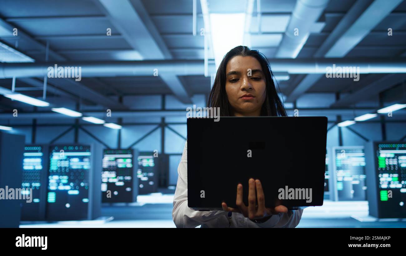 System administrator in high tech data center managing and maintaining databases, ensuring data integrity, security and availability. Manager overseeing server room, upgrading supercomputers systems Stock Photo