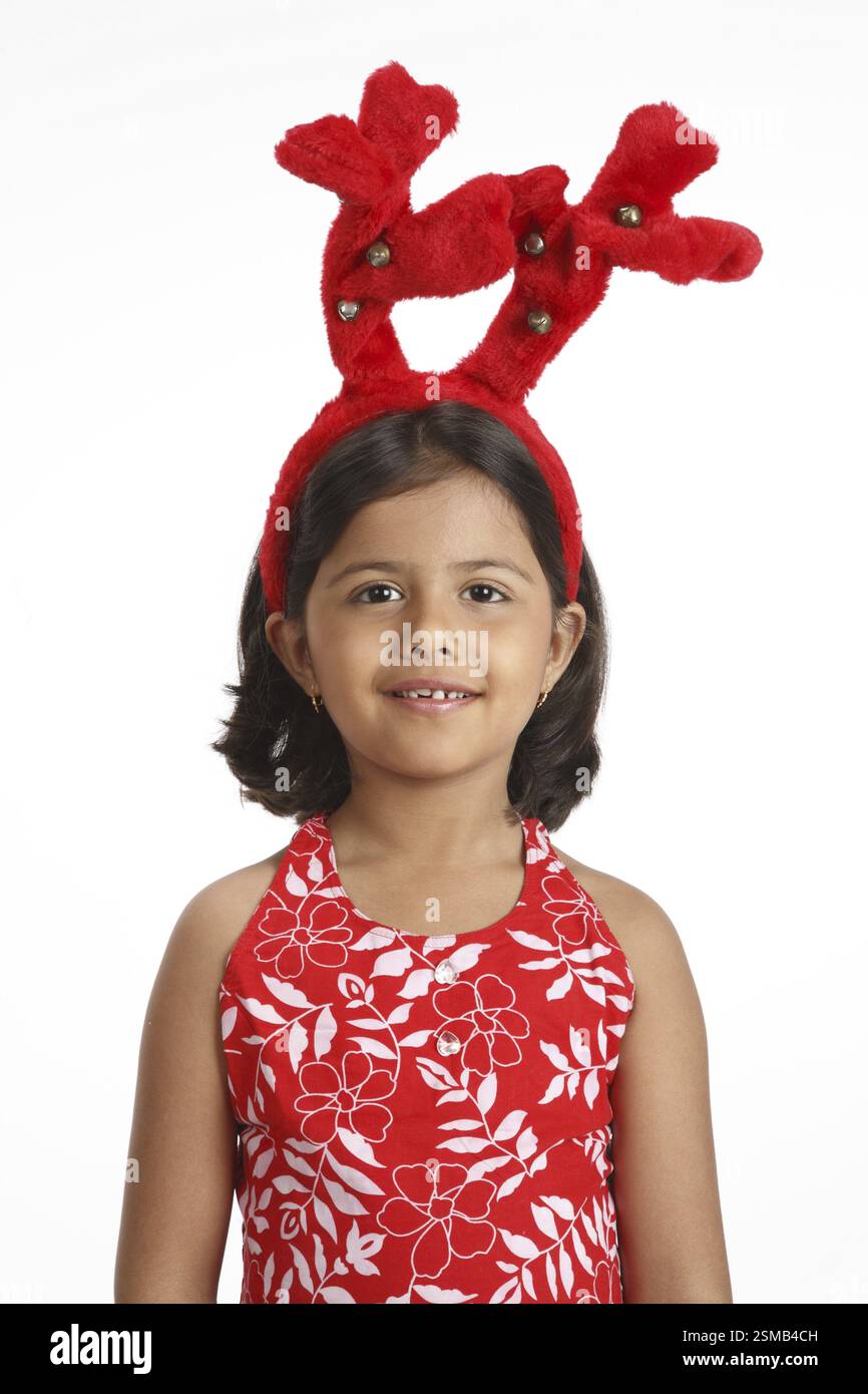 Eight year old girl wearing red color deer horns on head MR703U Stock