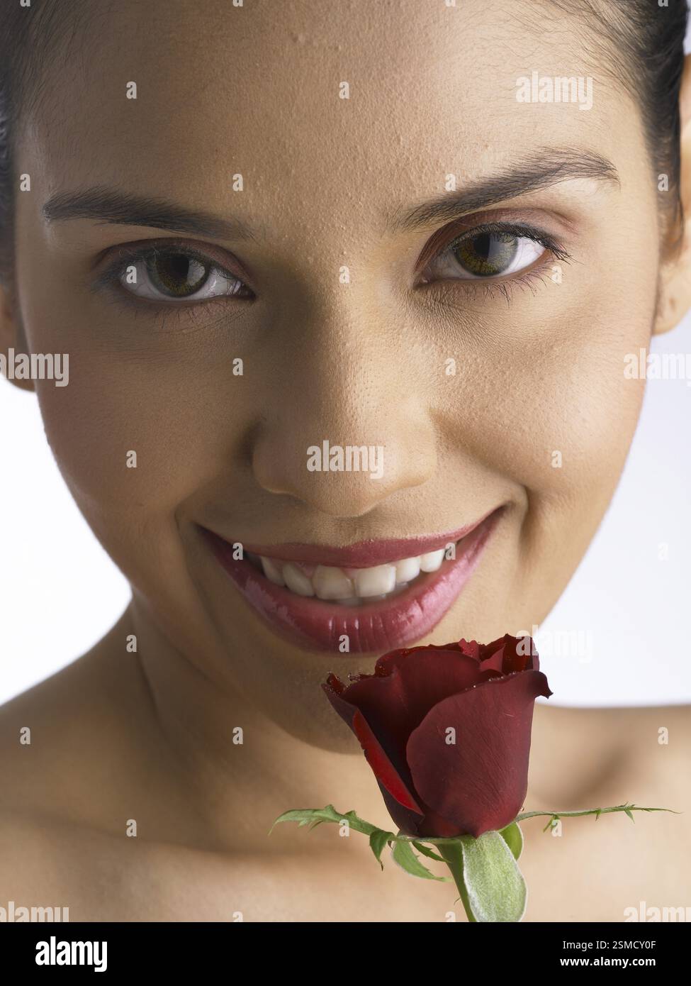 South Asian Indian woman smiling holding and smelling red rose MR # 702 ...