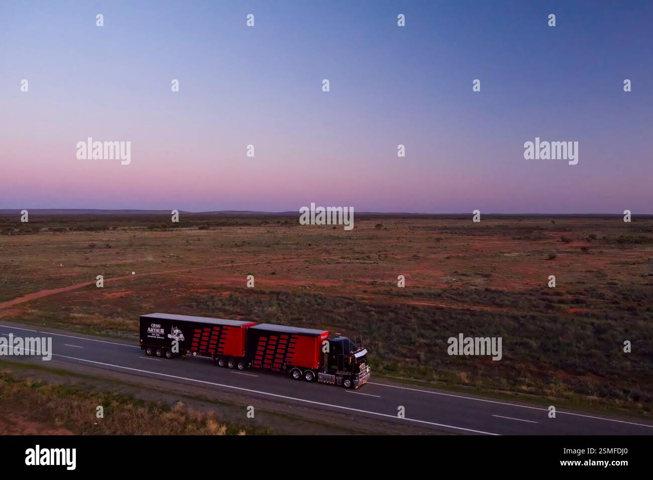 Interstate logistics truck heading into the sunset on the Barrier Highway New South Wales Australia Stock Photo