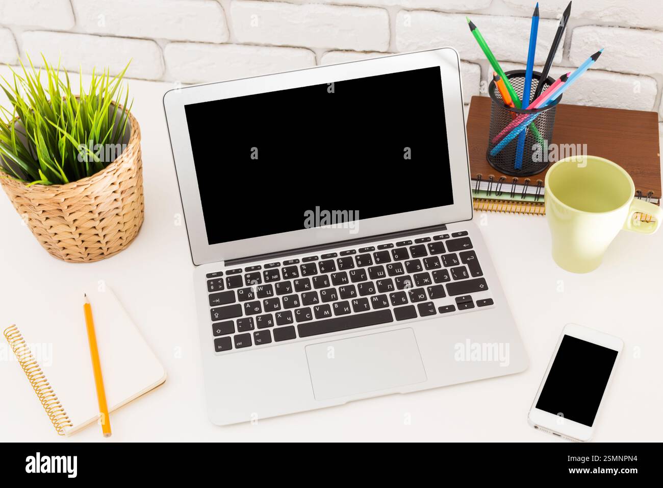 Workstation setup with laptop, stationery, and plants for a productive ...