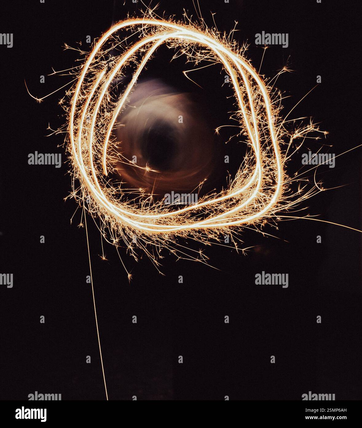 Painting with freeze light. Festive freezing lights in the night. Sparkling light trail. Stop light drawings. New Year fun. Firework background. Stock Photo