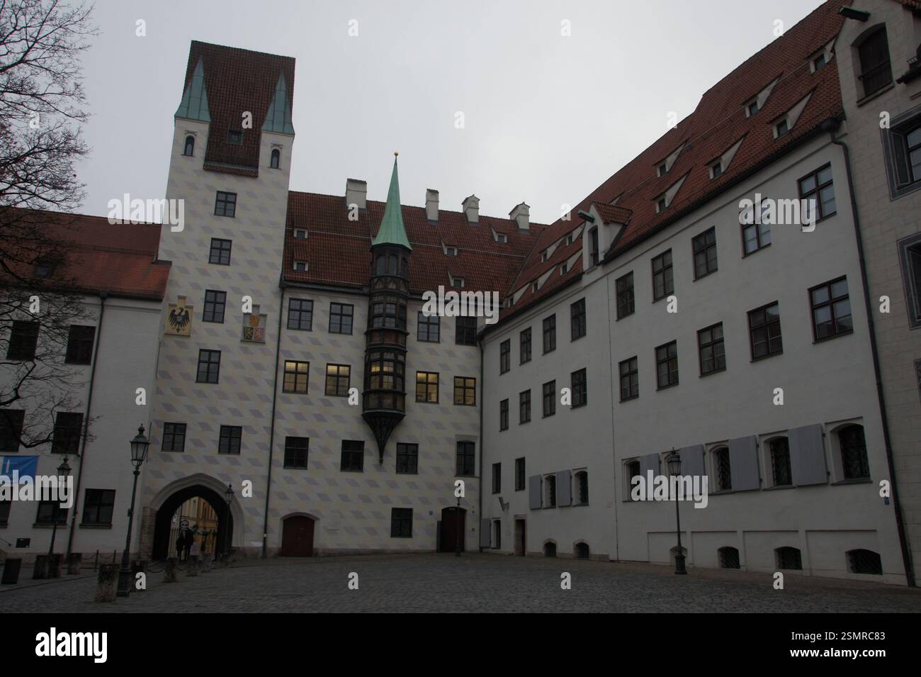 Grand white building with a red tile roof and a clock tower dominates ...
