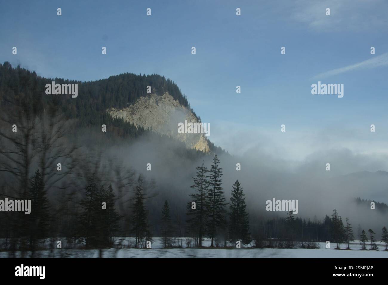 A snow-capped mountain in Germany, Munich, shrouded in fog creates a lofty peak with a mysterious atmosphere, like a winter wonderland hiding a secret Stock Photo