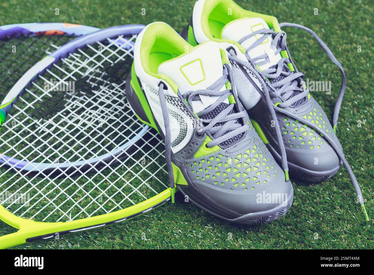 High-performance tennis shoes resting beside a racket on a vibrant ...