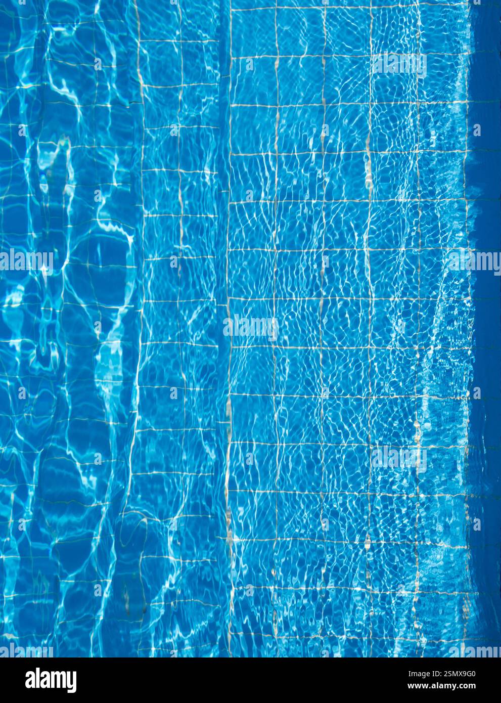 Calm blue water glistens under sunlight in a serene swimming pool ...