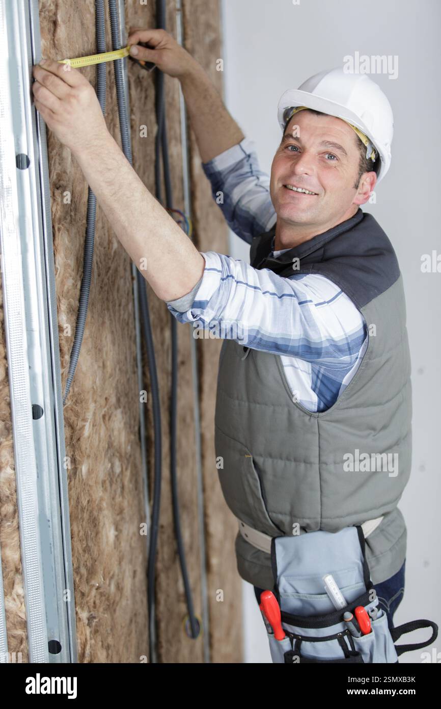 man is measuring insulation walls Stock Photo