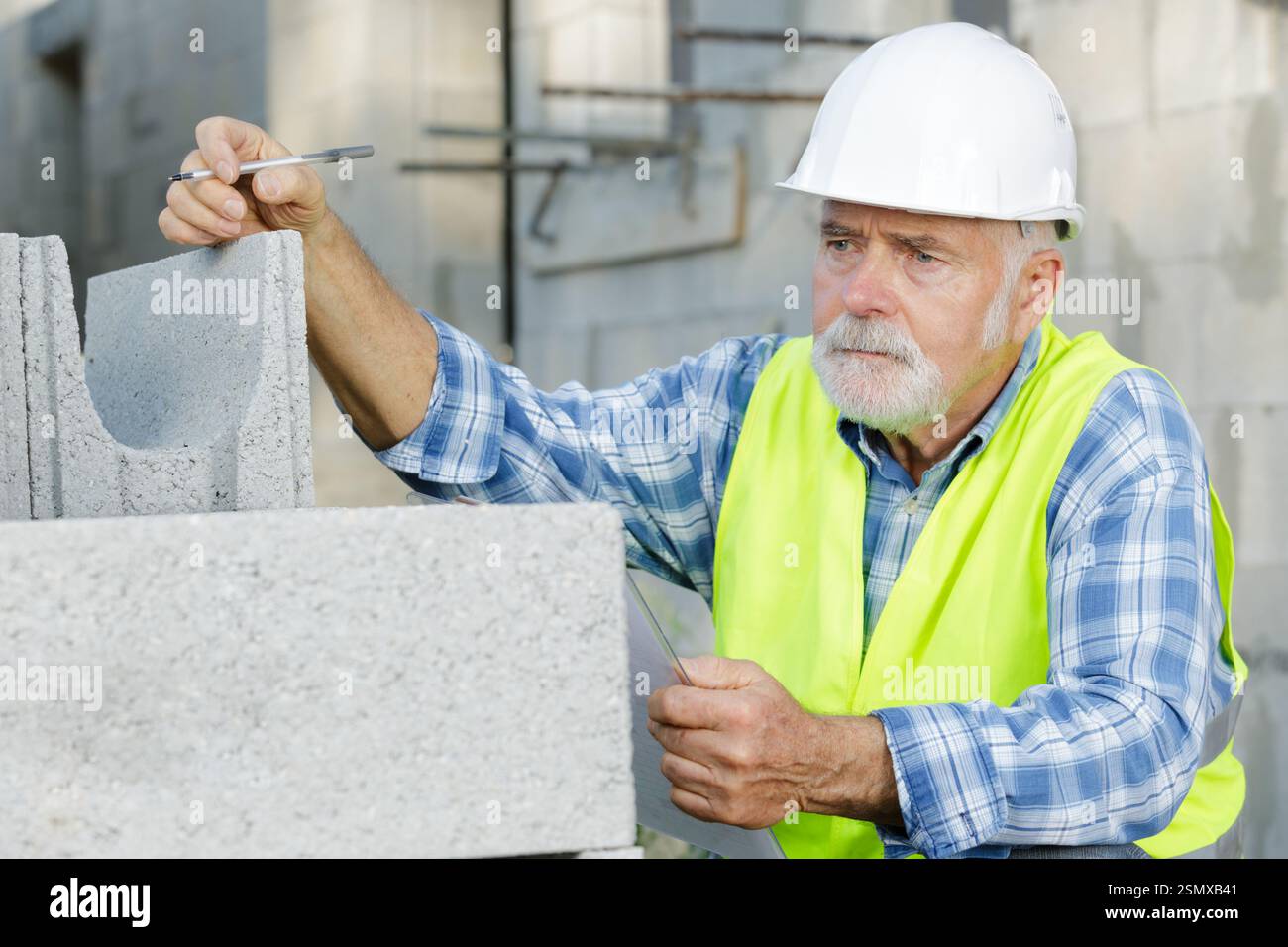 senior worker is checking cement outdoors Stock Photo