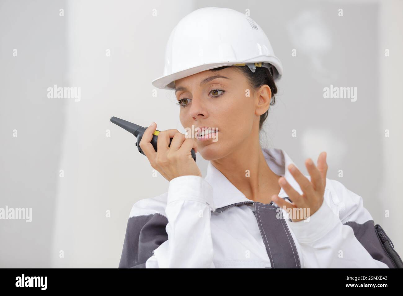 female builder using walkie talkie Stock Photo