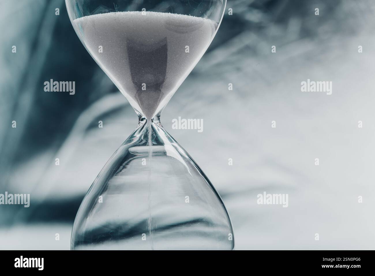 Elegant hourglass with fine sand flowing, symbolizing time passing in a ...