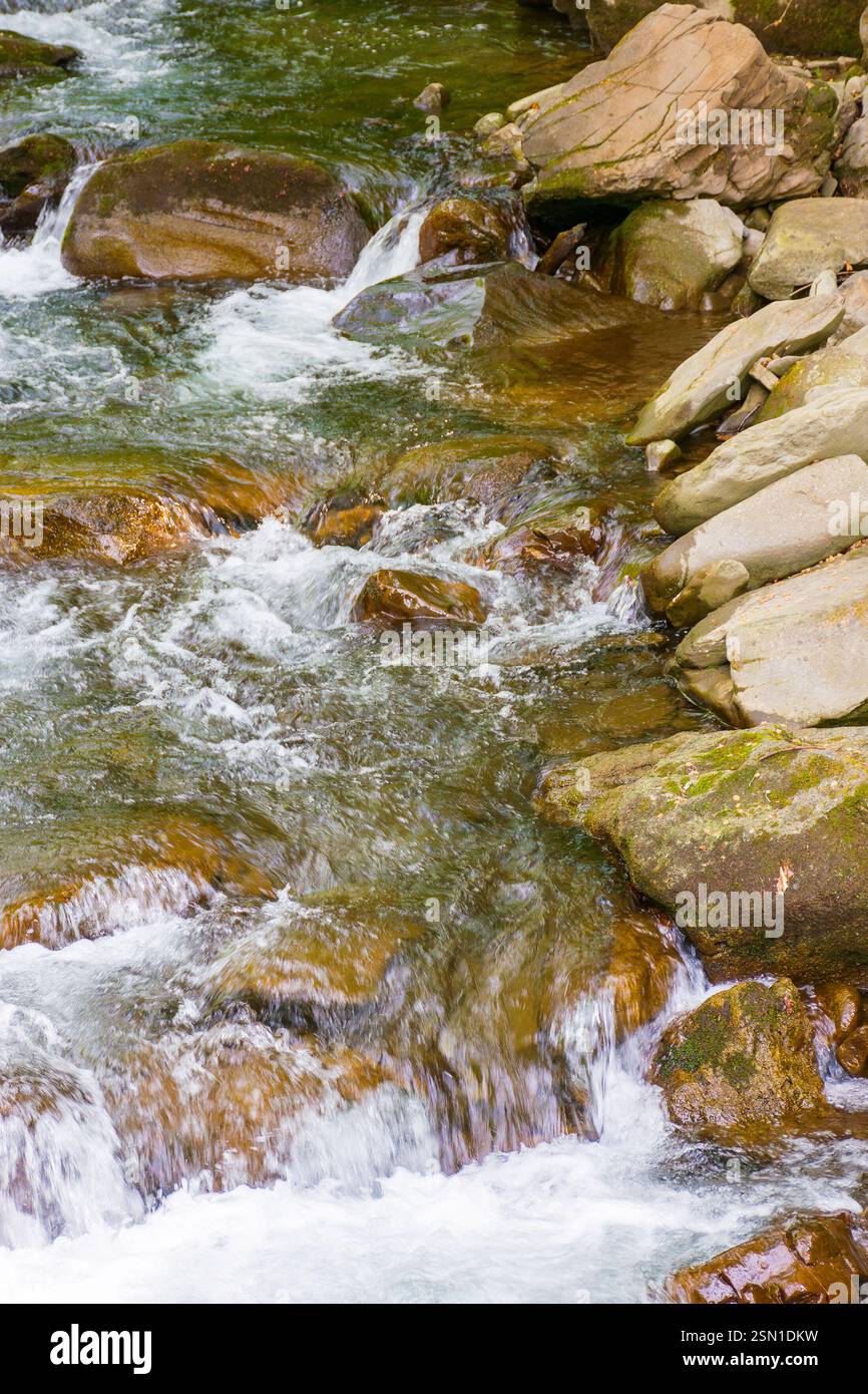rapid water stream among rocks and stones. beautiful nature background in romanian mountains. closeup view from above Stock Photo