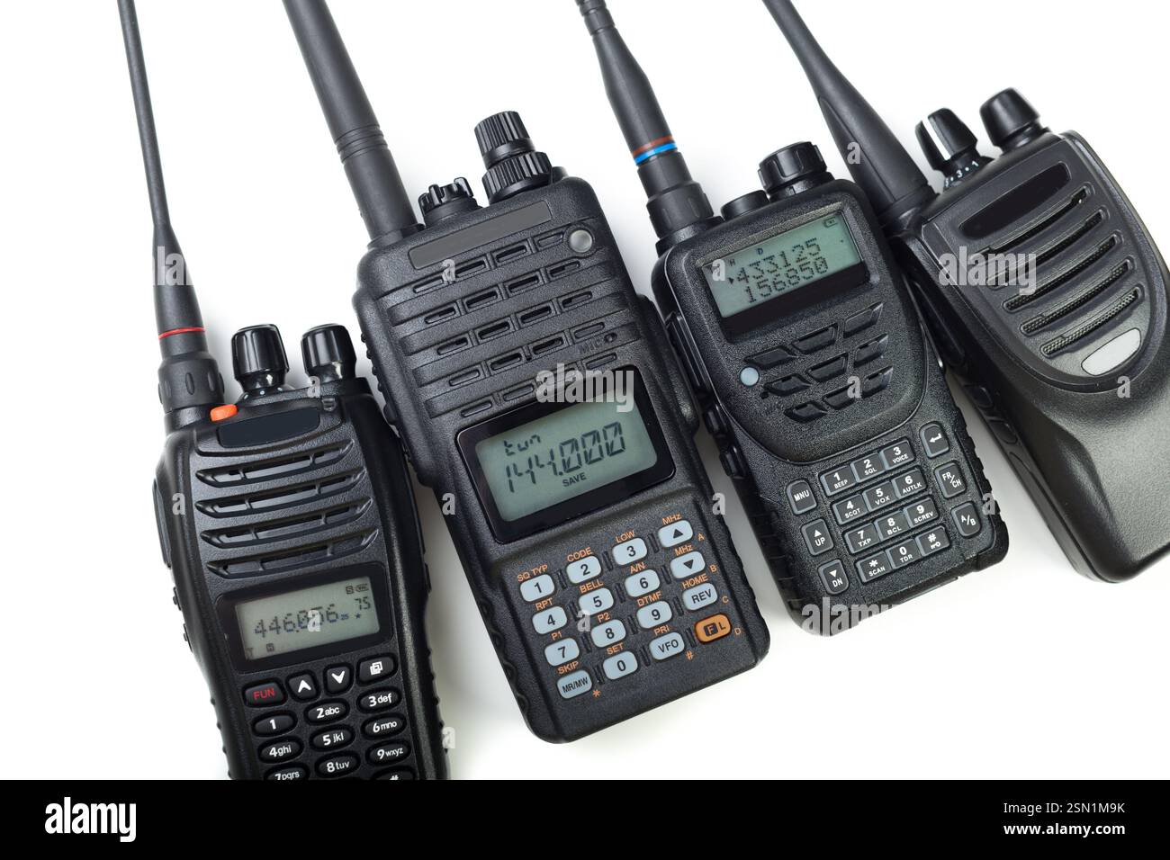 Collection of four handheld two-way radios arranged on a white ...